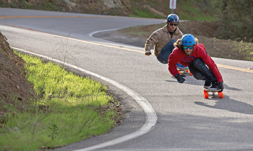 Couple of dudes going downhill on skateboards and wondering what's the best longboard wheel. 